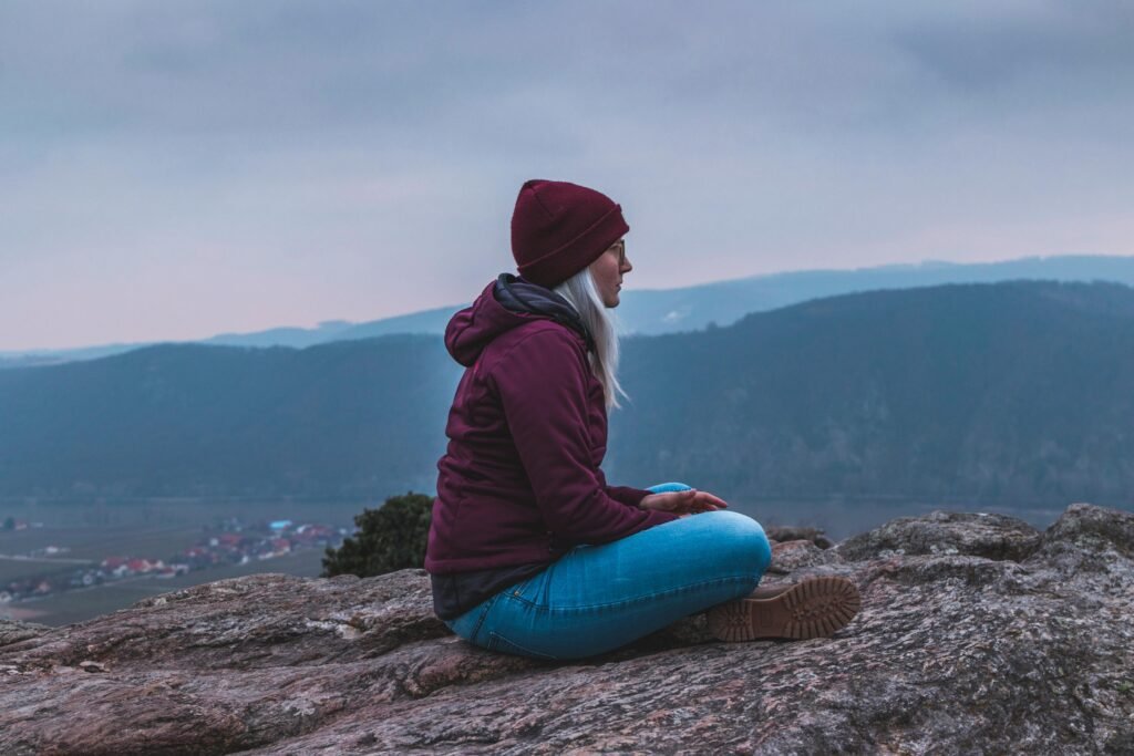 Woman sitting alone on a dirt path in a peaceful, reflective pose, symbolizing the quiet freedom and introspection of childfree life.