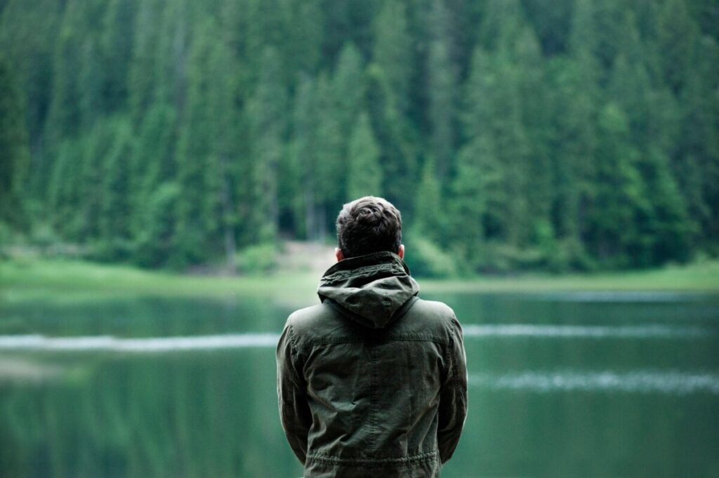 Kids Aren’t Kids Anymore: The Childfree Take – a peaceful childfree adult sitting by the water, reflecting on modern childhood and enjoying stress-free freedom.