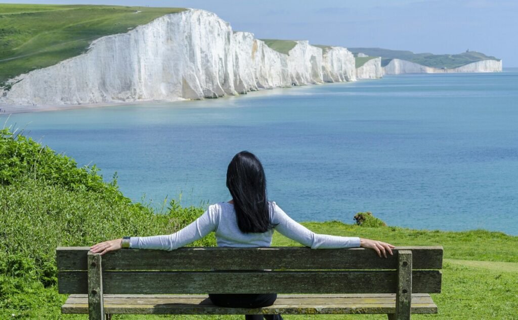 A thoughtful woman sitting alone on a bench, symbolizing reflection and freedom, representing the story My Childfree Journey Is Not a Rebellion But a Homecoming.