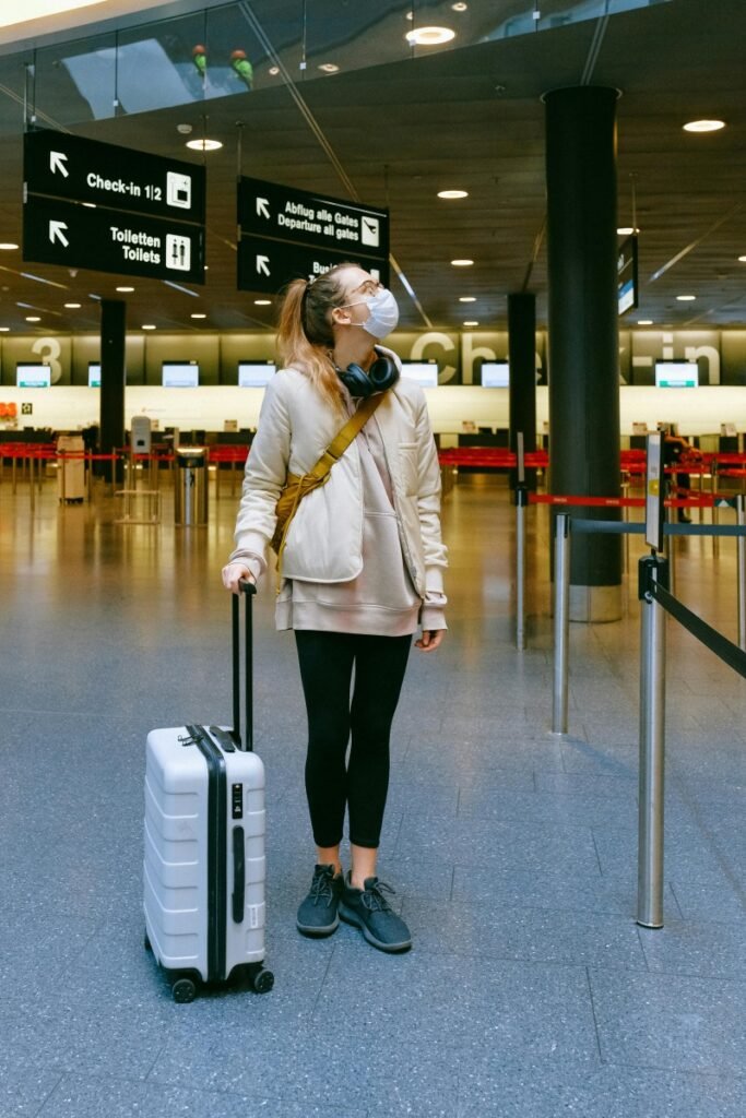 Woman waiting at an airport while traveling alone, representing common childfree travel mistakes.