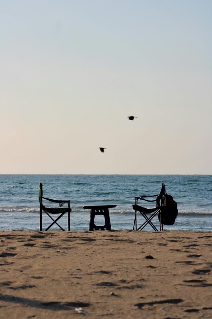 Empty beach chairs at sunset showing one of the most common childfree travel mistakes—ignoring the benefits of off-season travel.