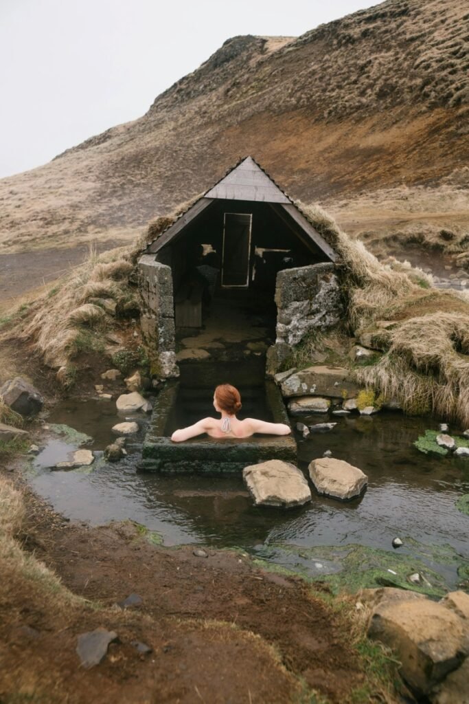 Woman relaxing in an outdoor stone bath, highlighting how childfree travel mistakes often come from ignoring rest.