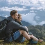 Couple embracing on a mountain overlooking the horizon, representing living a childfree life.