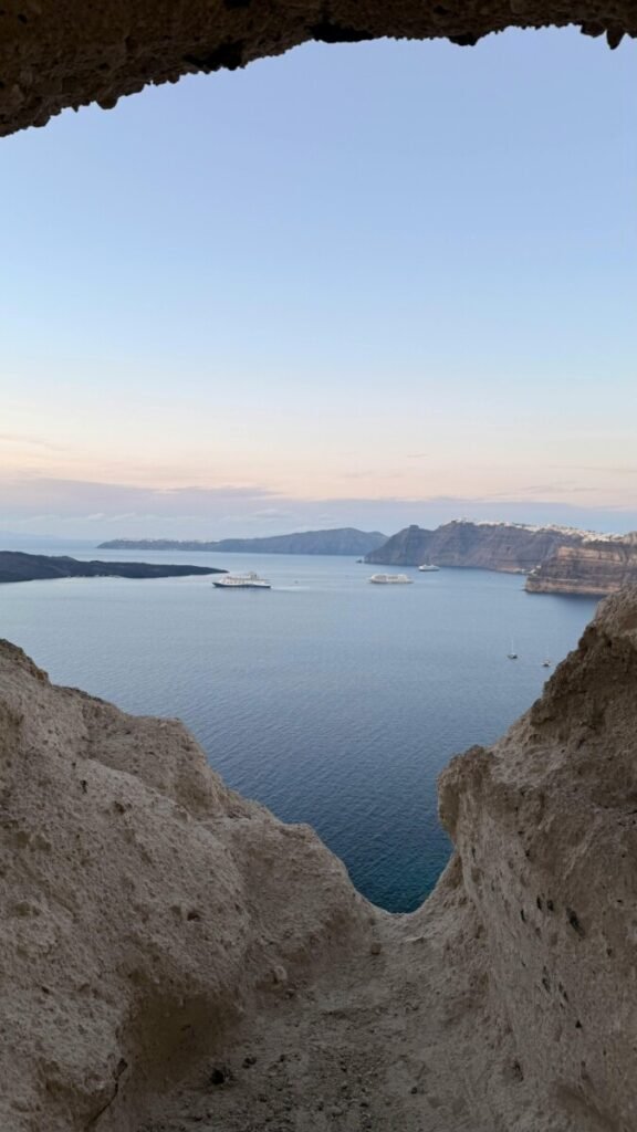 Santorini caldera view through a private cave suite, illustrating childfree luxury travel spending focused on peace, privacy, and sanctuary over extra space.