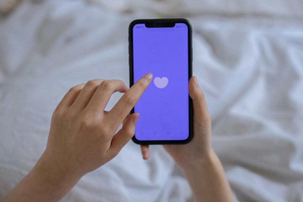 Smartphone with heart icon representing childfree dating apps and match selection.