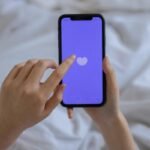 Smartphone with heart icon representing childfree dating apps and match selection.