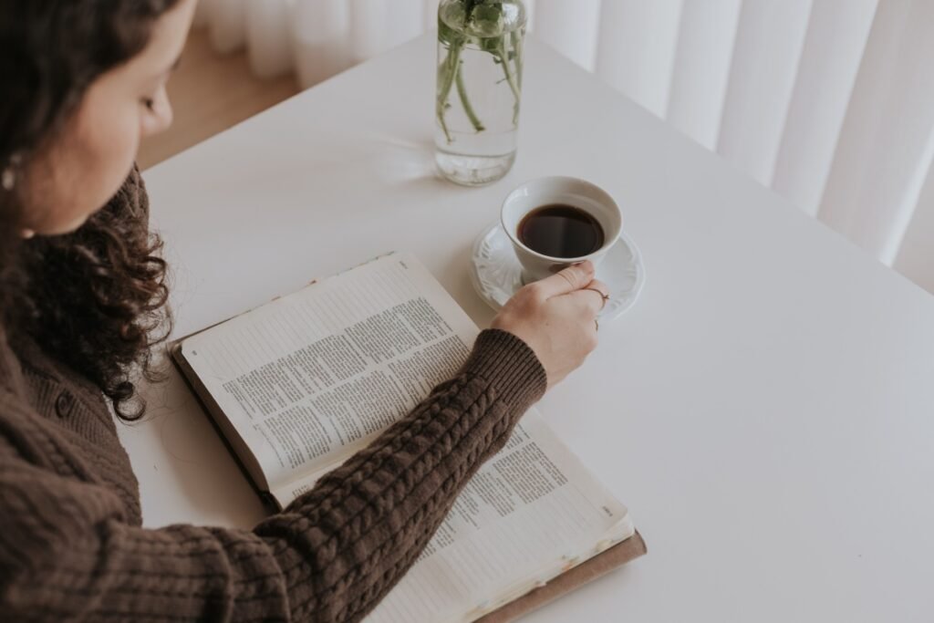Woman reading a book with coffee at home.