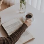 Woman reading a book with coffee at home.